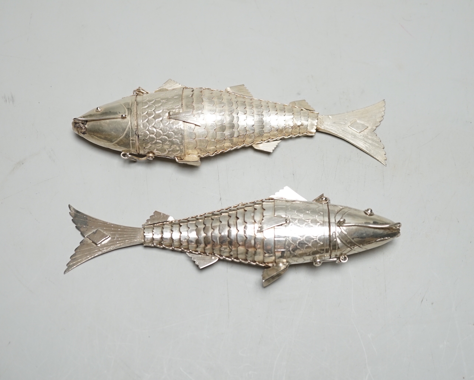 Two continental white metal pill boxes?, both modelled as a articulated fish, both approx. 13.5cm.